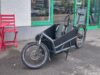 Ein sportliches Frontloader-Lastenrad mit zwei Kindersitzen in der Ladebox